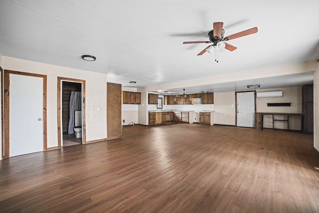 904 E Hester St, Brownfield, TX 79316 - unfurnished living room featuring an AC wall unit, dark wood-style floors, and a ceiling fan