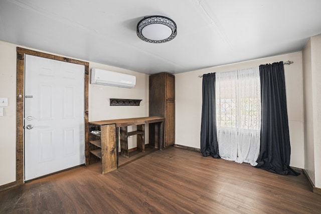 904 E Hester St, Brownfield, TX 79316 - unfurnished room with a wall mounted air conditioner, dark wood-type flooring, and baseboards