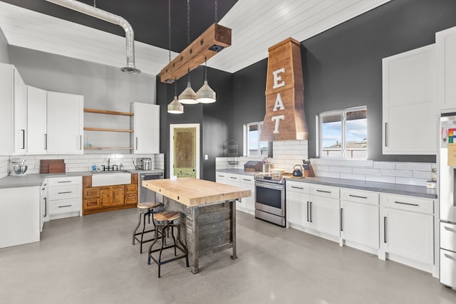 kitchen with white cabinets, a high ceiling, and appliances with stainless steel finishes