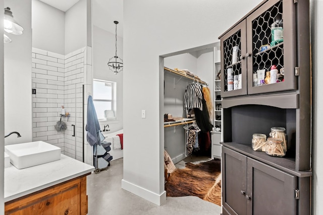 bathroom featuring a notable chandelier, vanity, and concrete flooring