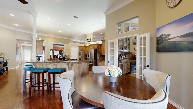 dining area featuring ornamental molding, beverage cooler, dark wood-type flooring, recessed lighting, and french doors