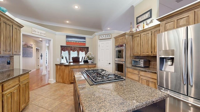 kitchen with appliances with stainless steel finishes, a kitchen island, recessed lighting, backsplash, and ornamental molding