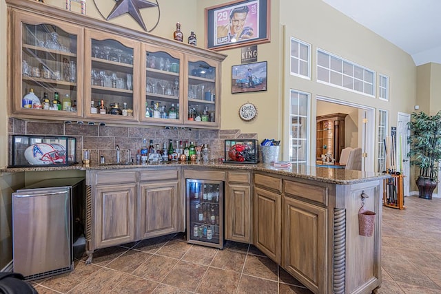 bar with beverage cooler, wet bar, and decorative backsplash
