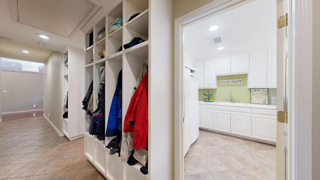 mudroom featuring recessed lighting, visible vents, a sink, and attic access