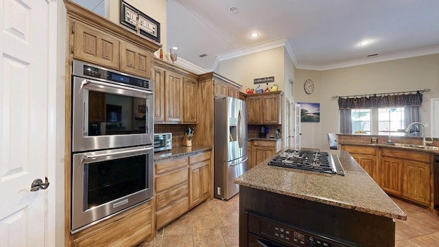kitchen with crown molding, decorative backsplash, a kitchen island, a sink, and stainless steel appliances