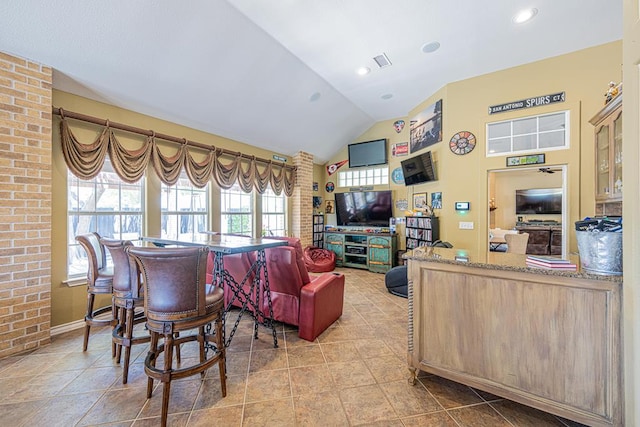 tiled living area featuring baseboards, vaulted ceiling, and visible vents