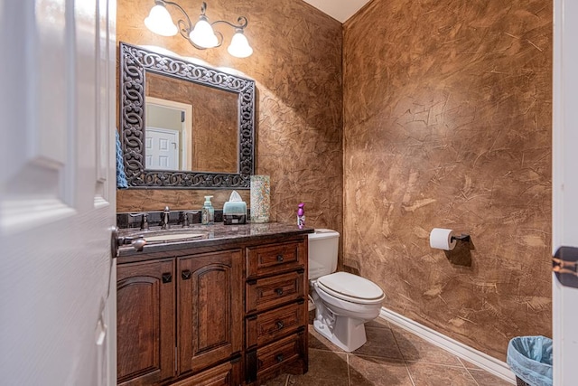 bathroom featuring toilet, tile patterned floors, baseboards, and vanity