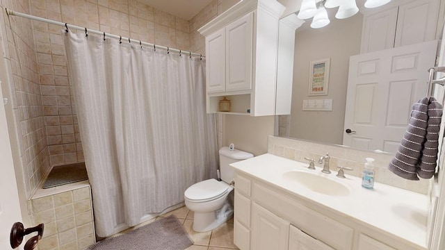 bathroom featuring vanity, tile patterned flooring, toilet, tiled shower, and a chandelier