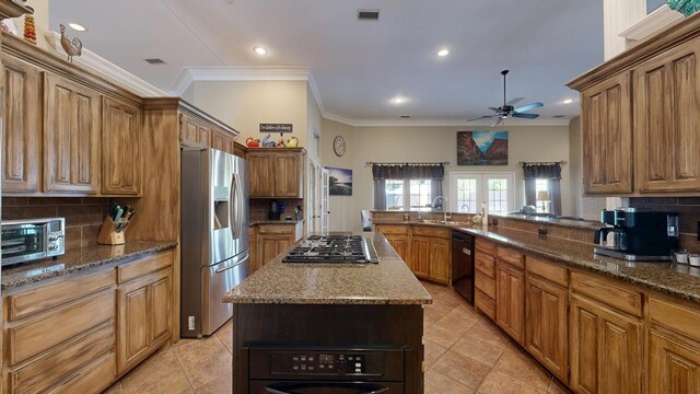 kitchen with ornamental molding, a ceiling fan, stainless steel appliances, and tasteful backsplash