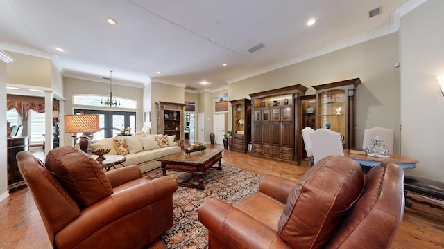 living room with recessed lighting, ornate columns, light wood-style flooring, and a notable chandelier