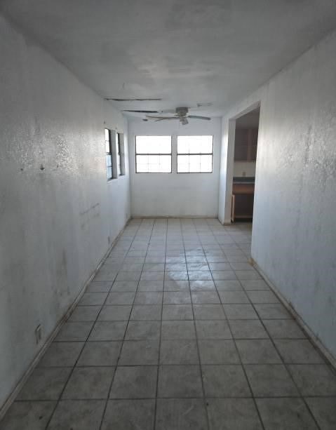 unfurnished room with ceiling fan and light tile patterned floors