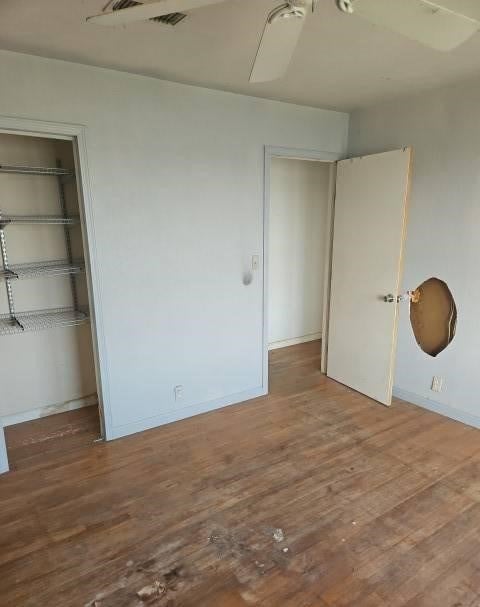 unfurnished bedroom with hardwood / wood-style flooring, a closet, and ceiling fan