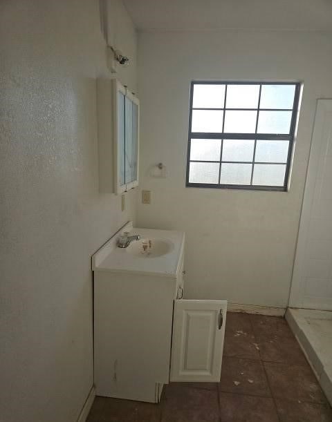 bathroom with tile patterned floors, vanity, and walk in shower