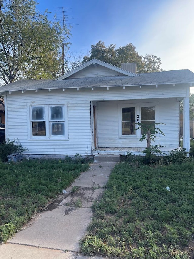 view of front of house featuring covered porch and a front yard