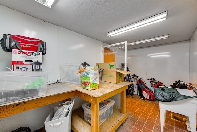 basement featuring tile patterned flooring and a textured ceiling