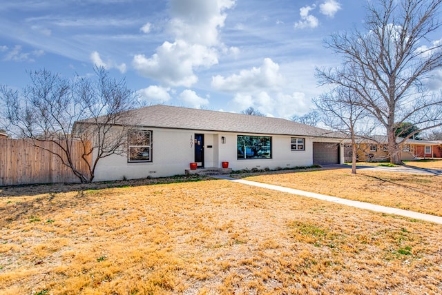 ranch-style house featuring a garage and a front lawn