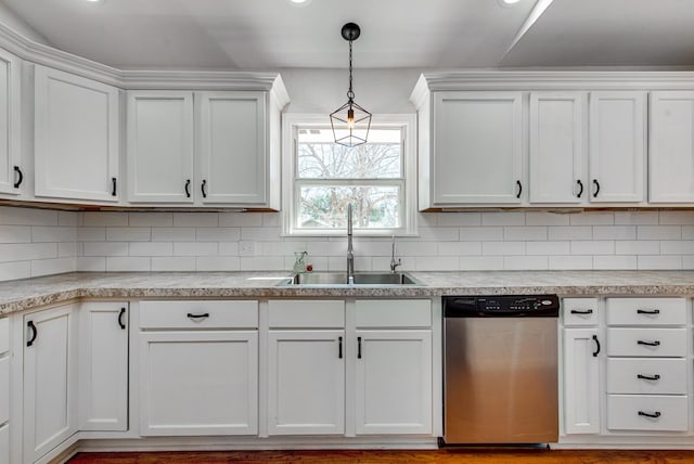 kitchen with white cabinetry, sink, stainless steel dishwasher, and hanging light fixtures