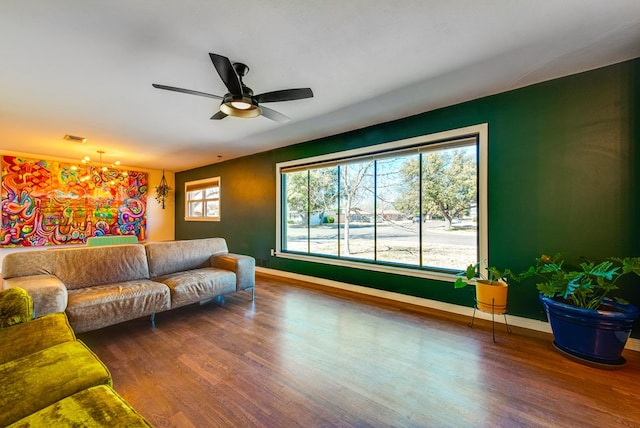 living room featuring hardwood / wood-style flooring and ceiling fan with notable chandelier