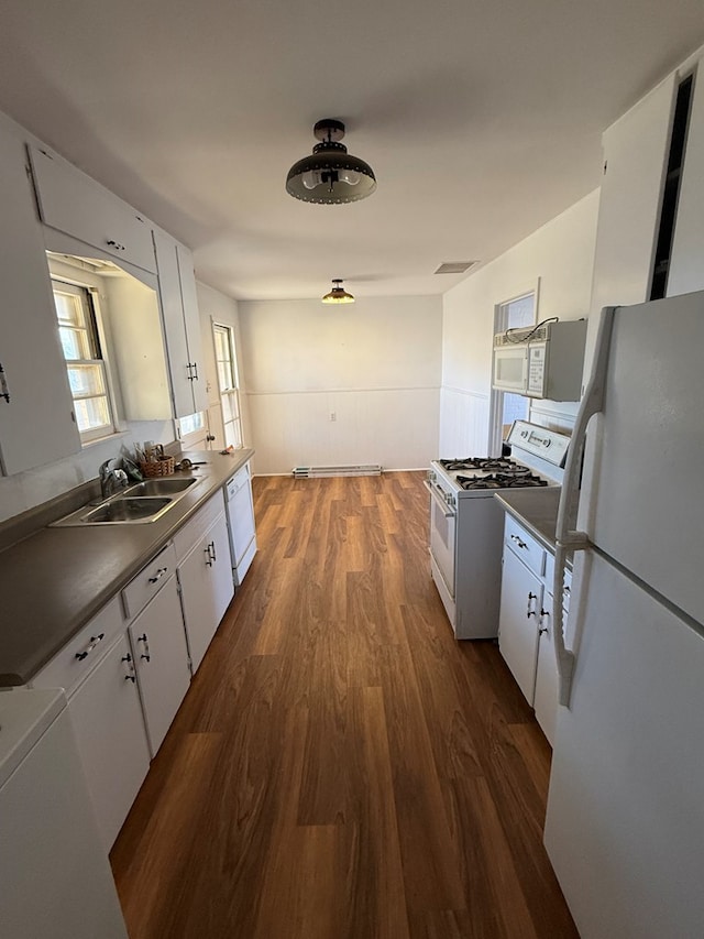 kitchen with sink, white cabinets, dark hardwood / wood-style floors, and white appliances