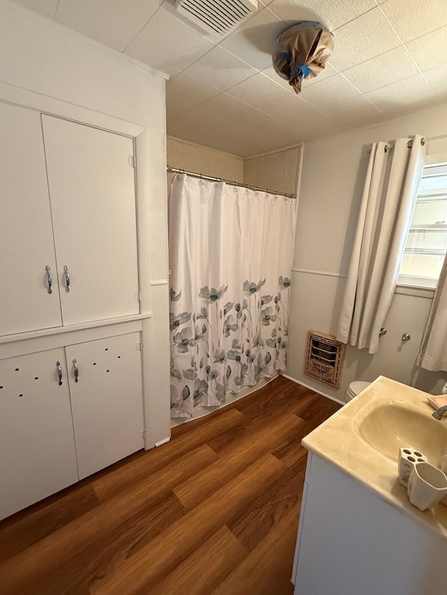 bathroom featuring hardwood / wood-style floors, vanity, and heating unit