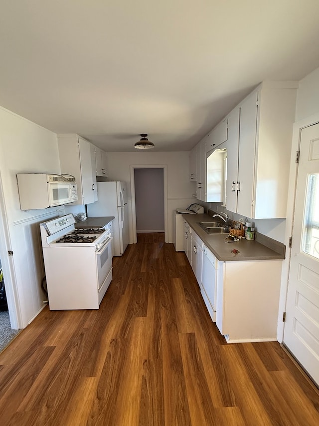 kitchen with white cabinets, white appliances, dark hardwood / wood-style floors, and sink