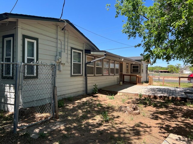 3702 Rose Cir, Snyder, TX 79549 - view of side of home featuring fence, a gate, and a deck