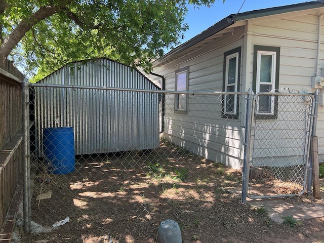 3702 Rose Cir, Snyder, TX 79549 - view of side of property with a fenced backyard, an outbuilding, and a gate