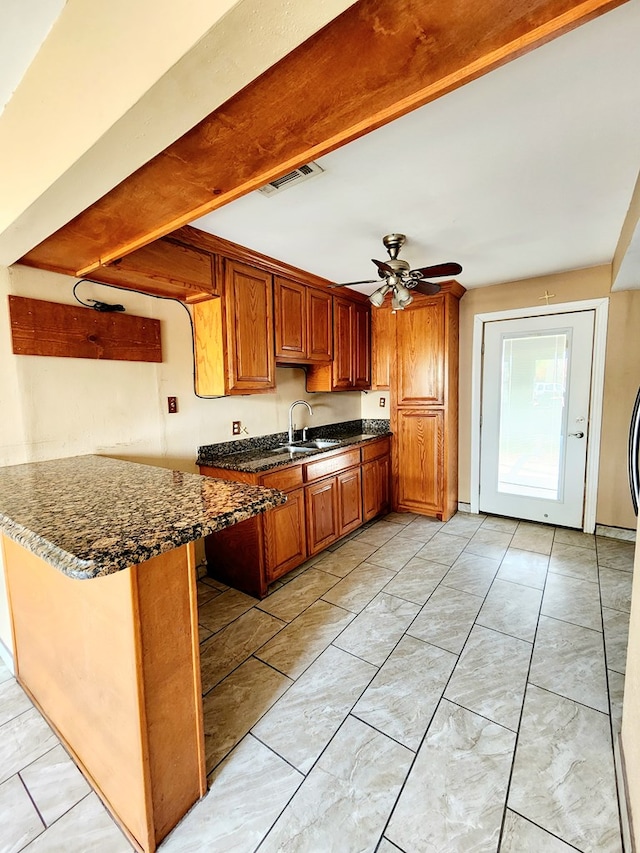 kitchen with kitchen peninsula, ceiling fan, and sink