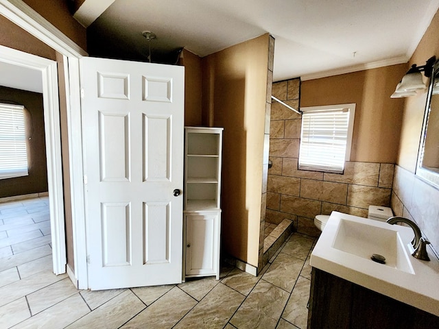 bathroom featuring tile patterned floors, walk in shower, vanity, tile walls, and toilet