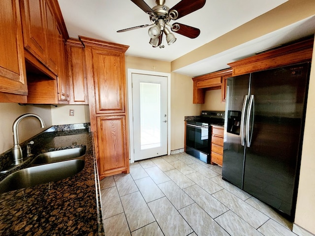 kitchen with ceiling fan, sink, black electric range oven, refrigerator with ice dispenser, and dark stone counters