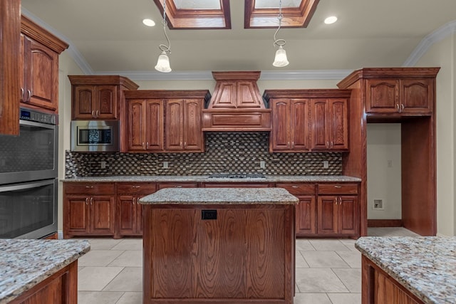 kitchen featuring appliances with stainless steel finishes, a kitchen island, light stone countertops, ornamental molding, and hanging light fixtures