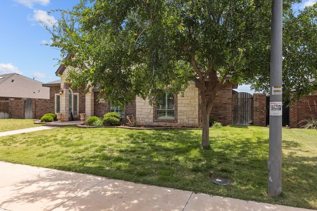 obstructed view of property featuring a gate, brick siding, and stone siding