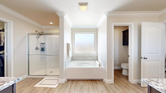 bathroom with a shower stall, toilet, wood finished floors, and ornamental molding