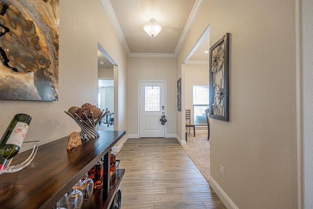 entrance foyer with a textured wall, crown molding, baseboards, and wood finished floors