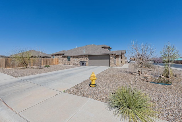 view of side of property with fence, a garage, and driveway