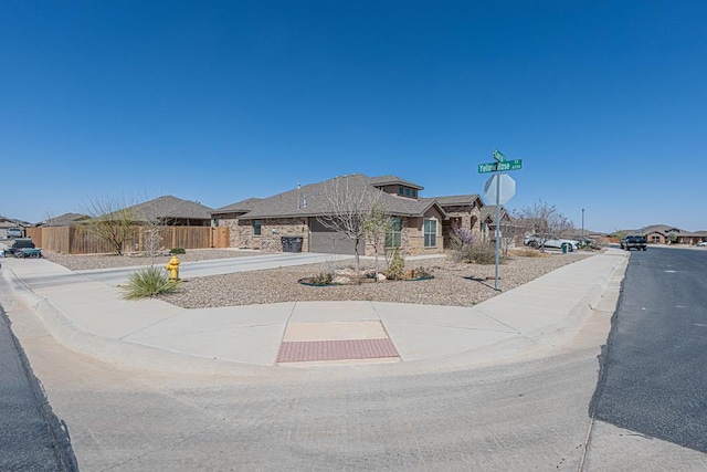 exterior space with a residential view, driveway, and fence