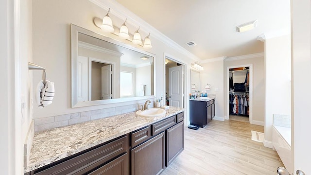 full bath with vanity, wood finished floors, visible vents, and backsplash