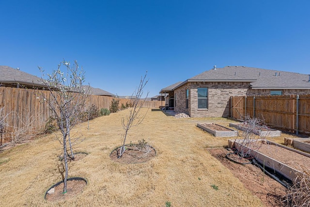 view of yard with a vegetable garden and a fenced backyard