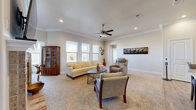 living area with crown molding, a brick fireplace, and visible vents