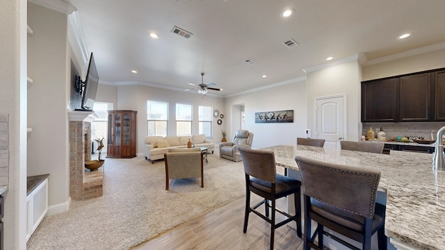 kitchen featuring visible vents, light stone countertops, dark brown cabinetry, and a fireplace