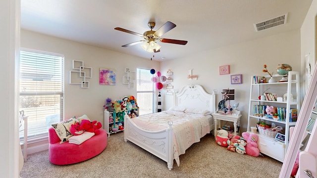 bedroom featuring a ceiling fan, visible vents, and light carpet