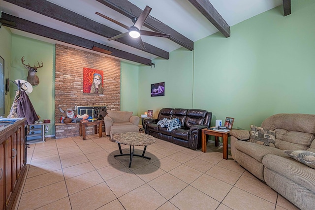 tiled living room featuring beamed ceiling, ceiling fan, and a fireplace