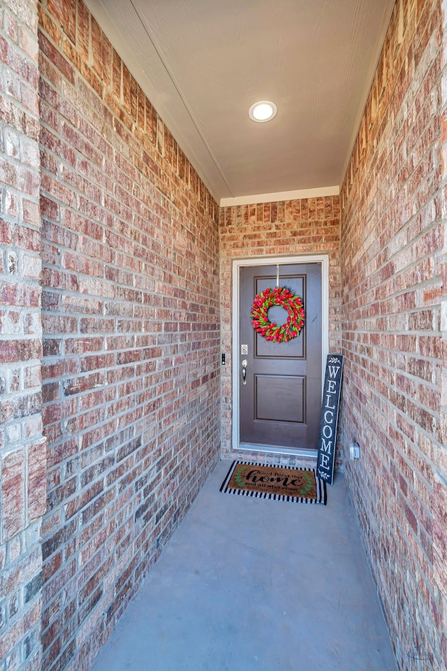 doorway to property featuring brick siding