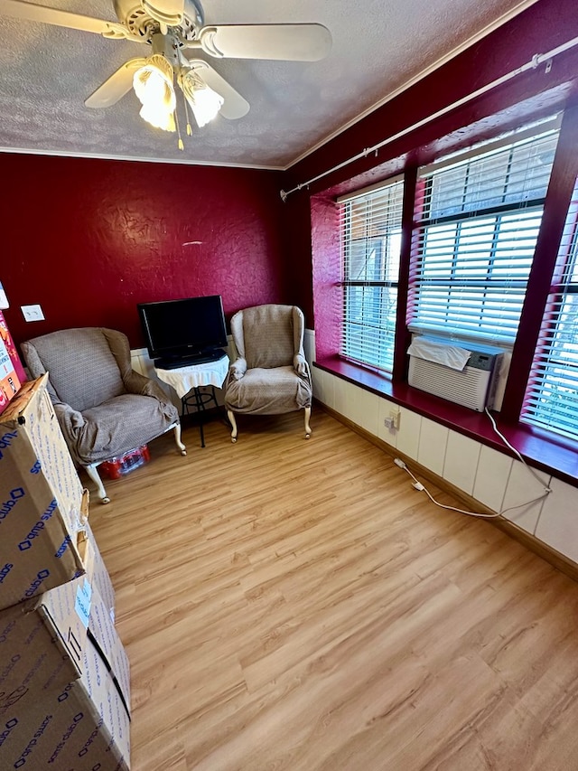 unfurnished room with a wealth of natural light, a textured wall, a textured ceiling, and wood finished floors