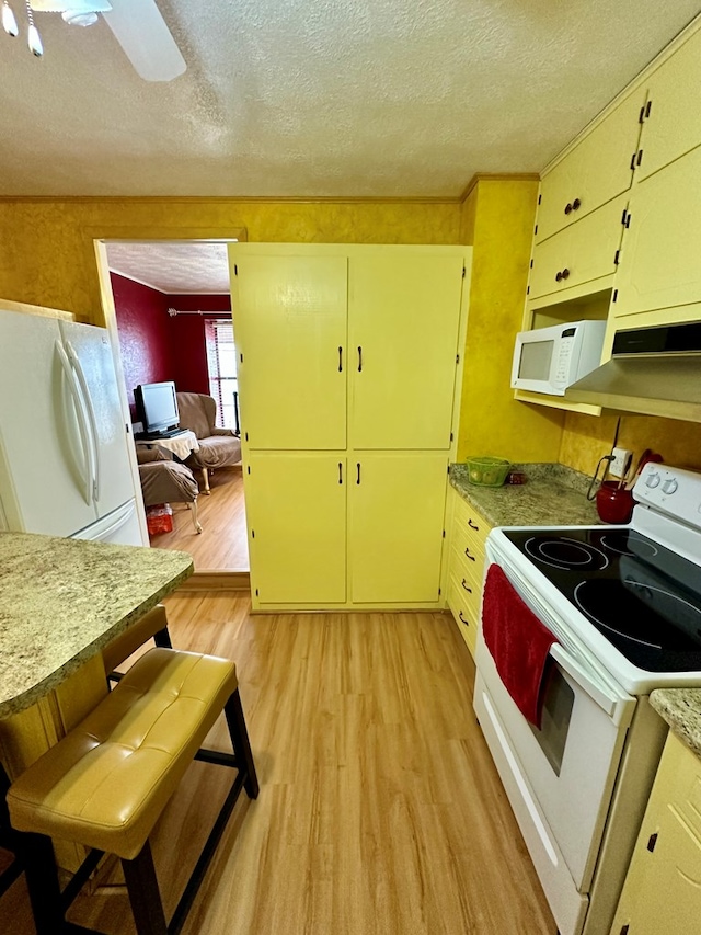 kitchen with a textured ceiling, ceiling fan, white appliances, light countertops, and light wood-type flooring