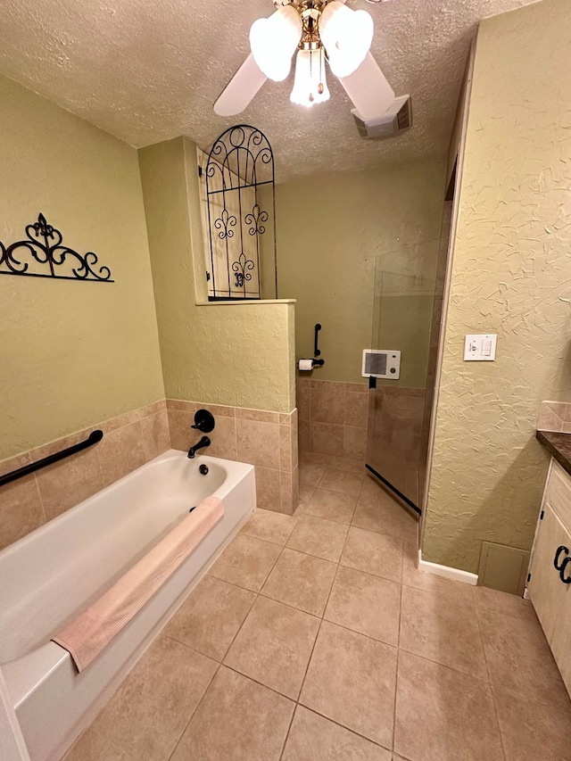 bathroom featuring a textured ceiling, a textured wall, vanity, and tile patterned floors