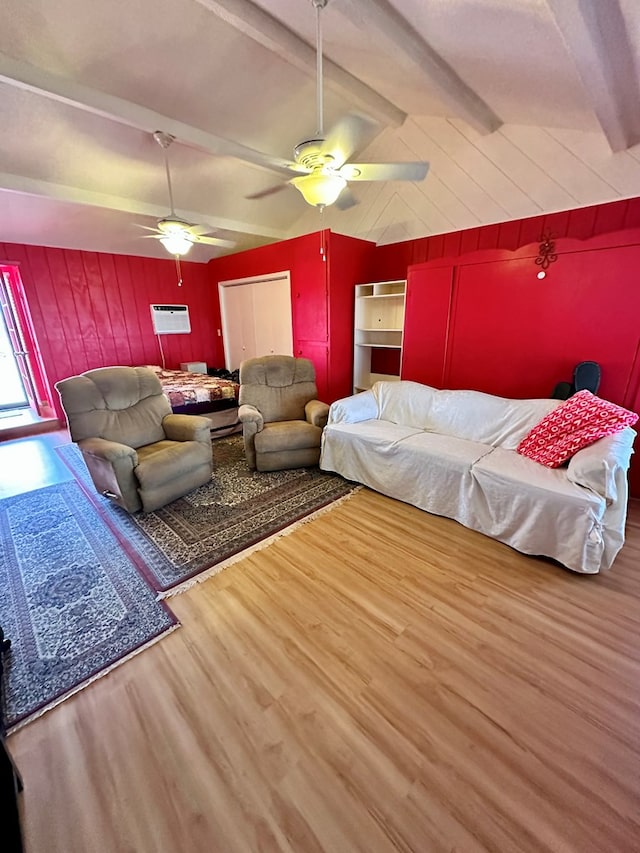 bedroom with vaulted ceiling with beams, wood walls, a ceiling fan, and wood finished floors