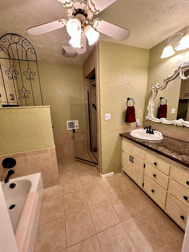 bathroom featuring tile patterned floors, vanity, a textured ceiling, and a textured wall