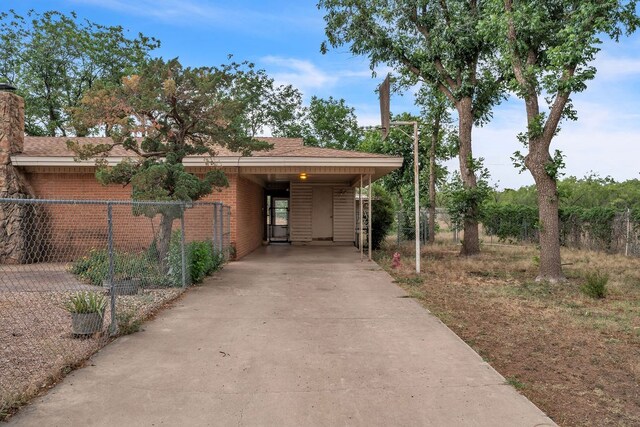 116 W Robinson Rd, Big Spring, TX 79720 - view of property exterior with concrete driveway, brick siding, a chimney, and roof with shingles