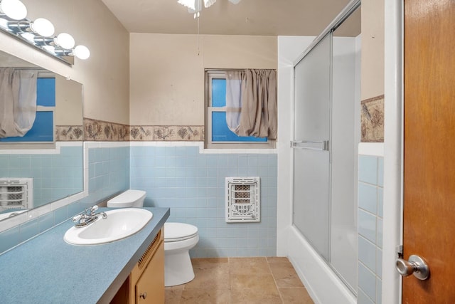 116 W Robinson Rd, Big Spring, TX 79720 - full bath with heating unit, toilet, vanity, tile walls, and a wainscoted wall